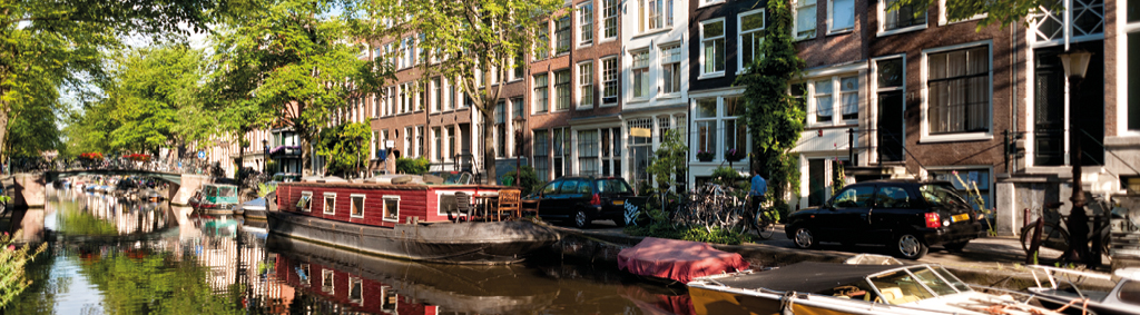 netherlands amsterdam canal boat colourful buildings